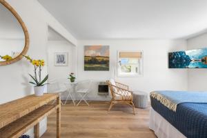 a bedroom with a bed and a desk and a table at Marina Bay Cottages in Waterford