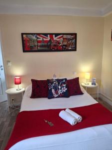 Un dormitorio con una gran cama blanca con almohadas rojas. en Le petit poucet, en Saint Lo