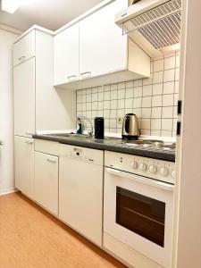 a kitchen with white cabinets and a stove at RhönZeit Apartements und Zimmer in Hilders