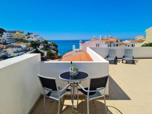 een tafel op een balkon met uitzicht op de oceaan bij SÍTIO DO RAPOSO - Carvoeiro - WiFi, AC, Beach & Center 200m in Carvoeiro