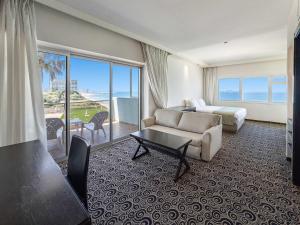 a hotel room with a couch and a bed and a window at The Sharon Seaside Retreat in Herzliya B +16 photos