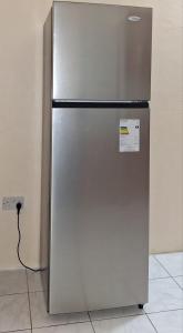 a stainless steel refrigerator with a cord plugged into an outlet at Sleeping Bueaty Gest House in Soufrière