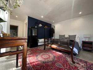 a large bedroom with a bed and a piano at Helder Haven Cottage in Somerset West