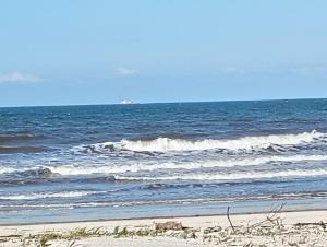 una spiaggia con alcune onde nell'oceano di Suítes a beira Mar a Canavieiras