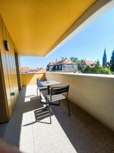 a balcony with a table and chairs on a roof at Résidence de Schiltigheim in Schiltigheim