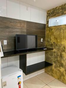 a flat screen tv sitting on top of a counter at Hotel Veneza in Garanhuns