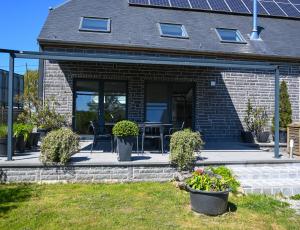 a house with a patio with a table and chairs at Le Maffe de Scourmont in Chimay