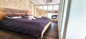 里夫杜海滩Evasion-iledere的一间卧室配有一张带枕头的紫色床。