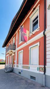 a orange building with a flag on the side of it at AMAO Amber - 120 m2 Group Apartment - 10 Guests - King-Size Beds - 2 Bathrooms - Free Parking in Rheinhausen