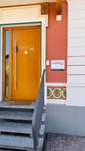a orange door of a building with stairs next to it at AMAO Amber - 120 m2 Group Apartment - 10 Guests - King-Size Beds - 2 Bathrooms - Free Parking in Rheinhausen