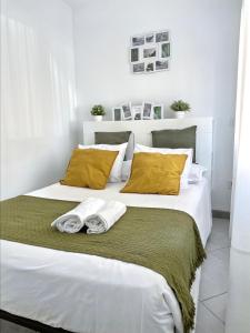 1 dormitorio con 2 camas blancas con almohadas amarillas en Como en casa, en Parla