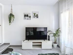 a white living room with a flat screen tv at Como en casa in Parla