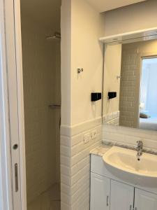 a white bathroom with a sink and a mirror at Maison d' Orange - Chambres in Saint-Tropez