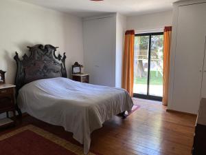 a bedroom with a large bed and a large window at Guincho Rural Villa in Cascais +17 photos