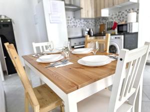 a wooden table with white plates and wine glasses at Como en casa in Parla +15 photos