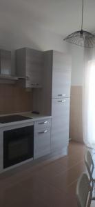 a kitchen with white cabinets and a black oven at Casa dei gerani in Montegiordano