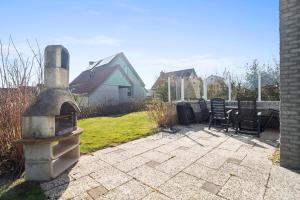 a outdoor pizza oven sitting on a patio at Vakantiehuis Sina in Julianadorp