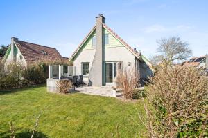 a house with a green roof and a yard at Vakantiehuis Sina in Julianadorp