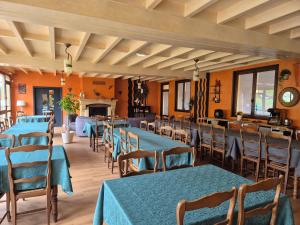 a dining room with blue tables and chairs at Gîte Bîn Vendüd Châ Nous in Le Monastier sur Gazeille