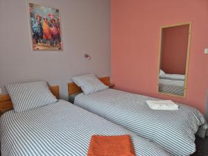 two twin beds in a room with a mirror at Gîte Bîn Vendüd Châ Nous in Le Monastier sur Gazeille +2 photos