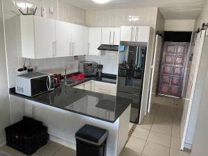 a kitchen with white cabinets and a black counter top at 3 Eden Sands in Kingsborough
