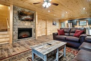 ein Wohnzimmer mit Couch und Kamin in der Unterkunft Serene Cabin with Hot-tub and Fire Pit in Pigeon Forge, Tennessee in East Fork