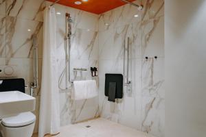 ein Badezimmer mit Dusche, Toilette und Waschbecken in der Unterkunft AMERON Luzern Hotel Flora in Luzern + 46 Fotos