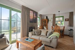 a living room with a couch and a table at Vakantiehuis Sina in Julianadorp