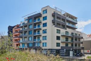 a tall apartment building with balconies on a hill at Luxury Sea View Apartment in Pomorie in Pomorie