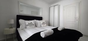 a white bedroom with a bed with pillows on it at Perfect Stay - "Campari Glam Apartments" in Toruń