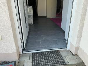 an open door to a hallway with a tile floor at AAM Ferienwohnung 75qm Saarlouis citynah PP WiFi in Saarlouis