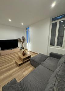 a living room with a couch and a flat screen tv at Logement Neuf JJ appartement à La Ciotat in La Ciotat