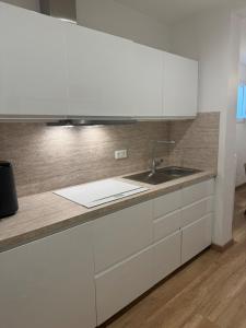 a kitchen with white cabinets and a sink at Logement Neuf JJ appartement à La Ciotat in La Ciotat