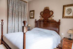 a bedroom with a large bed with a wooden headboard at Finca Orate in Mairena del Alcor +48 photos