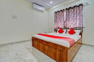 Un dormitorio con una cama grande con almohadas rojas. en Hotel O BlueBird Service Apartment, en Nagpur
