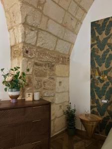 a room with a stone wall and a vase of flowers at Dimore Remegi in Brindisi