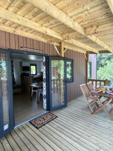 a covered deck with a table and chairs on it at Location du Ranch Cantarettu in Algajola