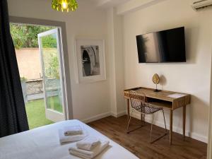 a bedroom with a bed and a desk and a window at Maison d' Orange - Chambres in Saint-Tropez