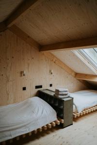 a room with two beds and a desk in a attic at Bed en Brood in de Kapschuur - Boerderij de ZuiderKRIB in Kraggenburg