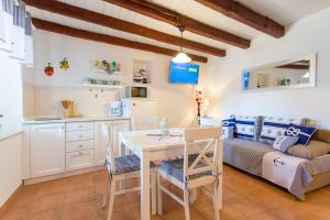 een keuken en een woonkamer met een tafel en stoelen bij St. Bernhard House in Funtana