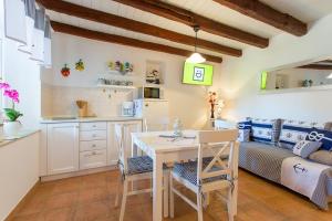 een keuken en woonkamer met een tafel en stoelen bij St. Bernhard House in Funtana