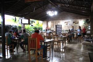 a group of people sitting at tables in a restaurant at Hotel Barroso in Pirapora