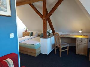 a bedroom with a bed and a desk and a chair at Zur Eiche - Pension in Böhlen
