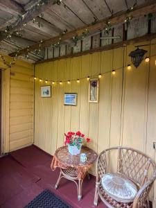 a patio with a table and chairs and flowers on it at KurBrauksim Goldingen Apartments in Kuldīga
