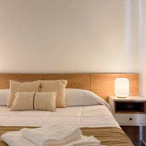 a bedroom with a large white bed with a lamp at Rossi Tiny in Villa Mercedes +9 photos