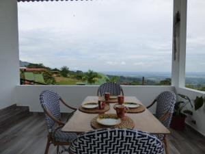 a table and chairs on a balcony with a view at Nido Acacias Cabaña romántica con jacuzzi Azulejo in Acacías +47 photos