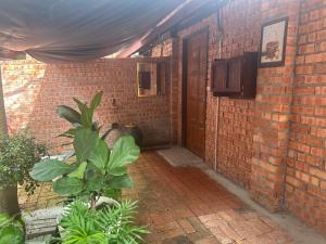 波德申Lelangit Inn的砖砌的建筑,有门,有植物