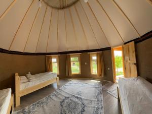 a large room with a bed and a rug at Bosogo Yurt camp in Bokonbayevo +27 photos