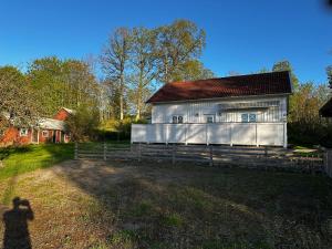 a shadow of a person standing in front of a white barn at Sörbyvägen 6 in Floby +12 photos