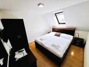 a bedroom with a large bed with white sheets at Penzion PANDA Tourist in Turčianske Teplice